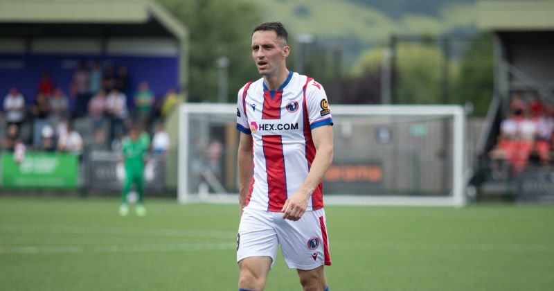 player wearing dorking wanderers 2023-24 home shirt in white and red